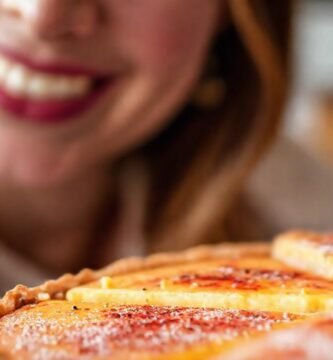 Una mujer sonríe con tarta caliente