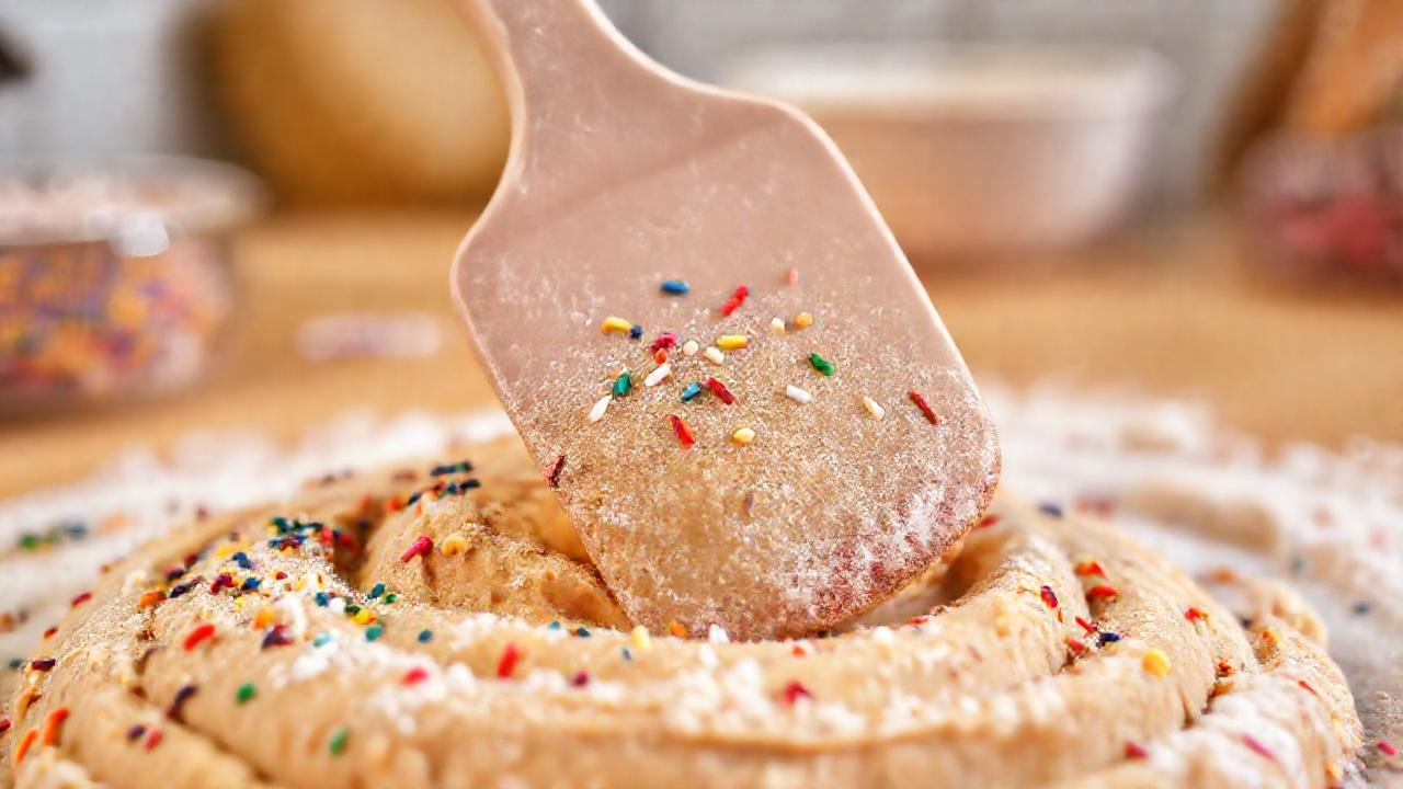 Un pastelero feliz extiende masa en cocina